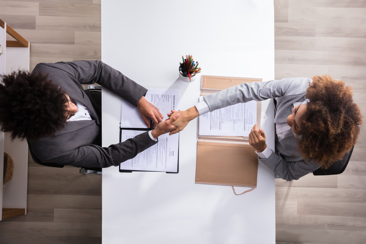 two people in suits shaking hands. concept for a good outcome to employment claims