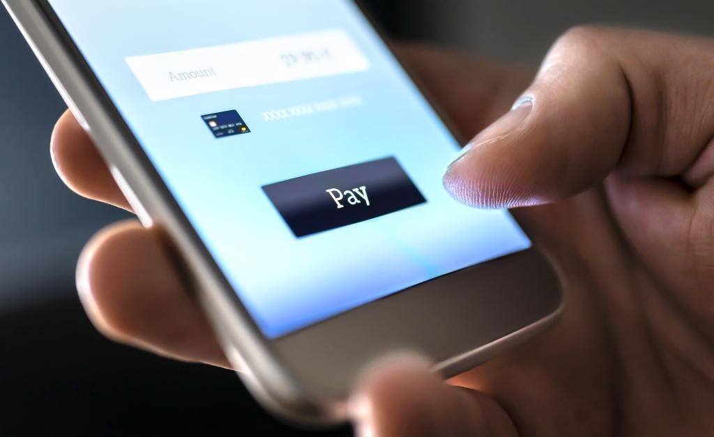 Payment transfer on mobile phone symbolising push payment fraud