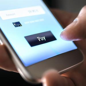 Payment transfer on mobile phone symbolising push payment fraud