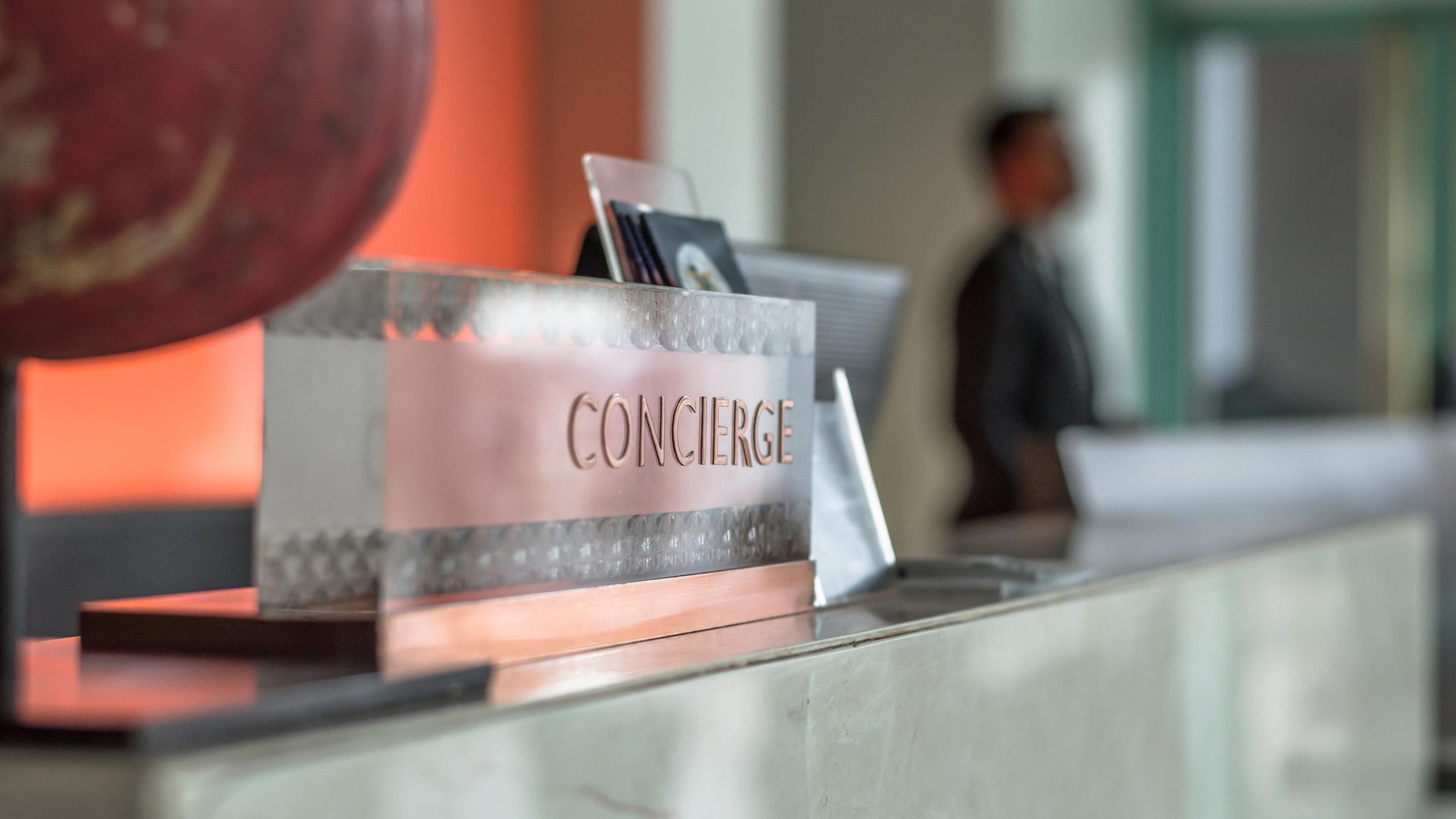 a concierge plaque on a hotel reception desk