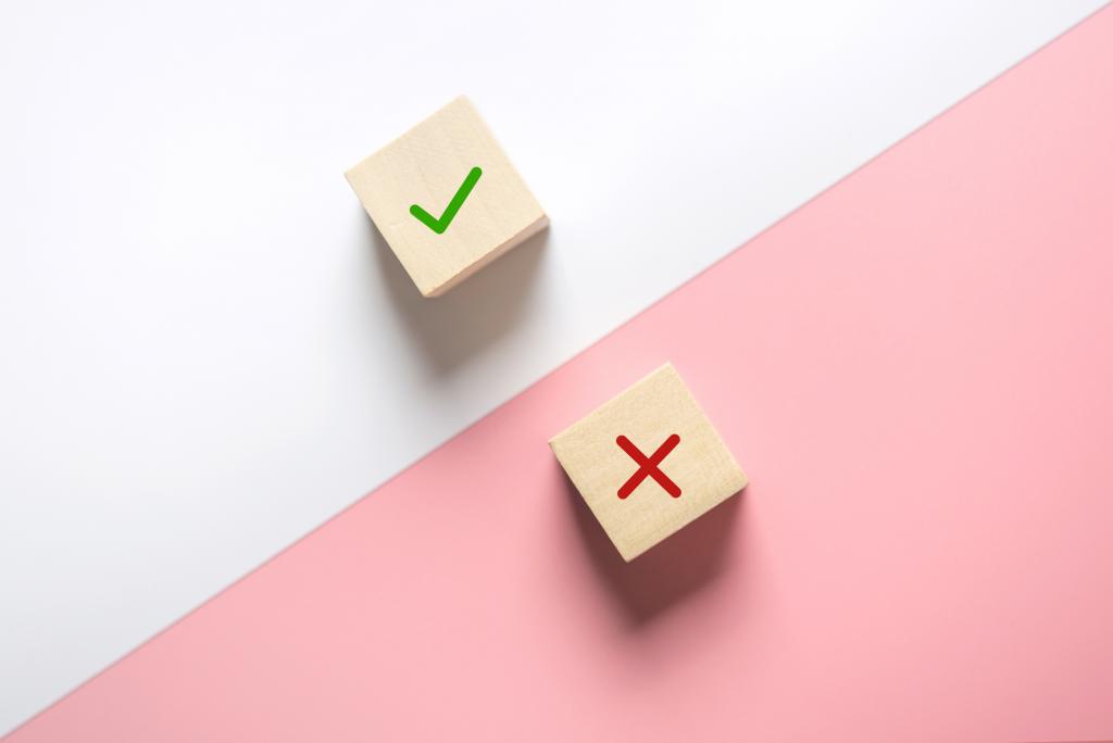 photo of two wooden blocks, one with a checkmark and the other a cross