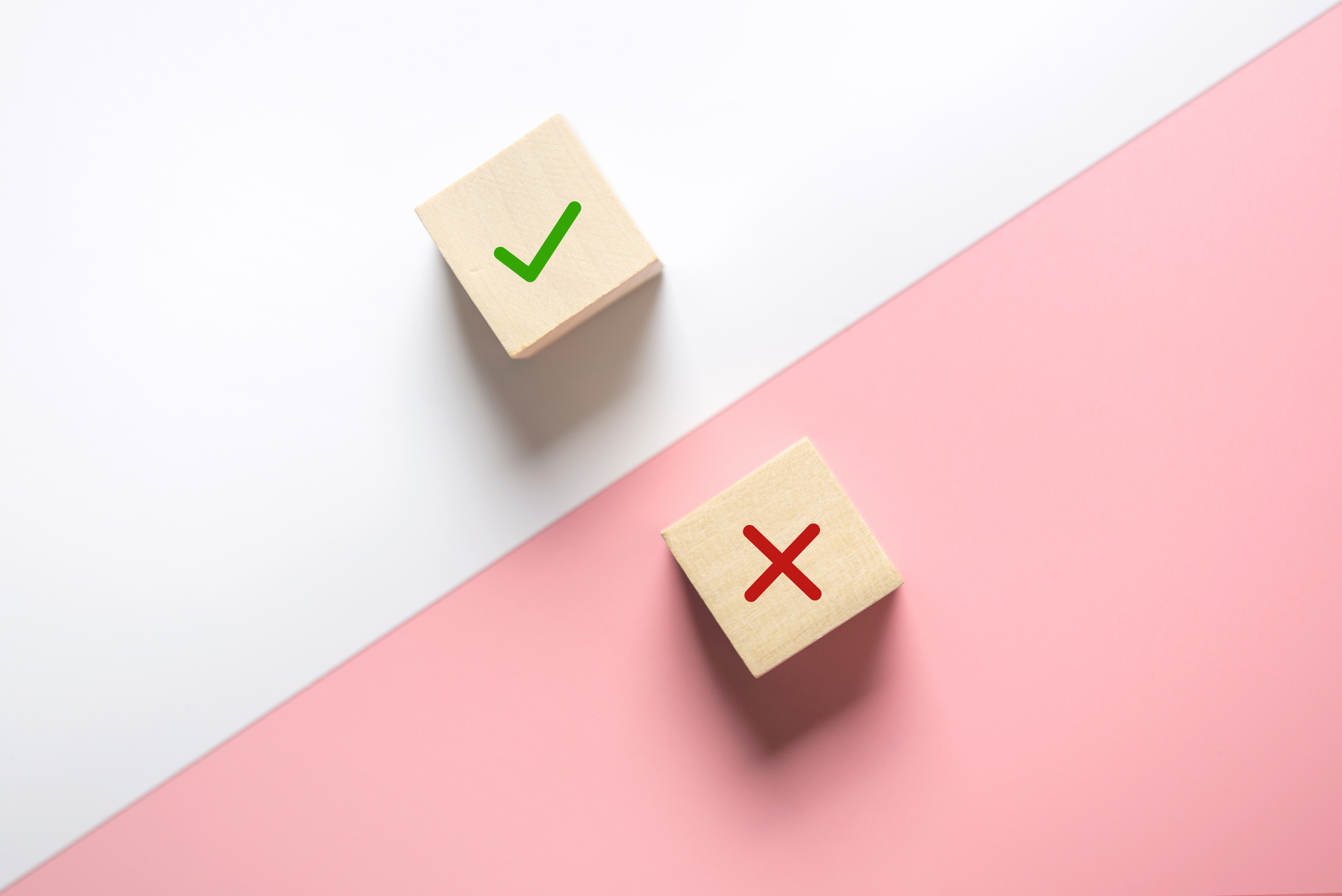 photo of two wooden blocks, one with a checkmark and the other a cross