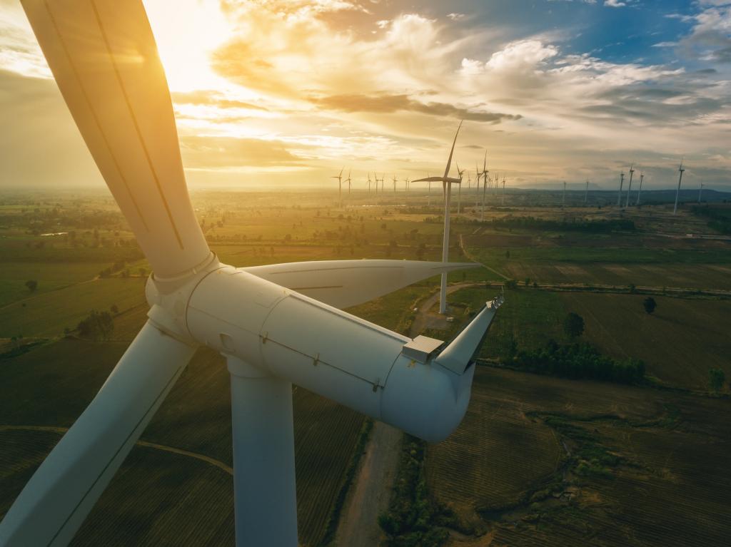 a photo of multiple wind turbines in an open area