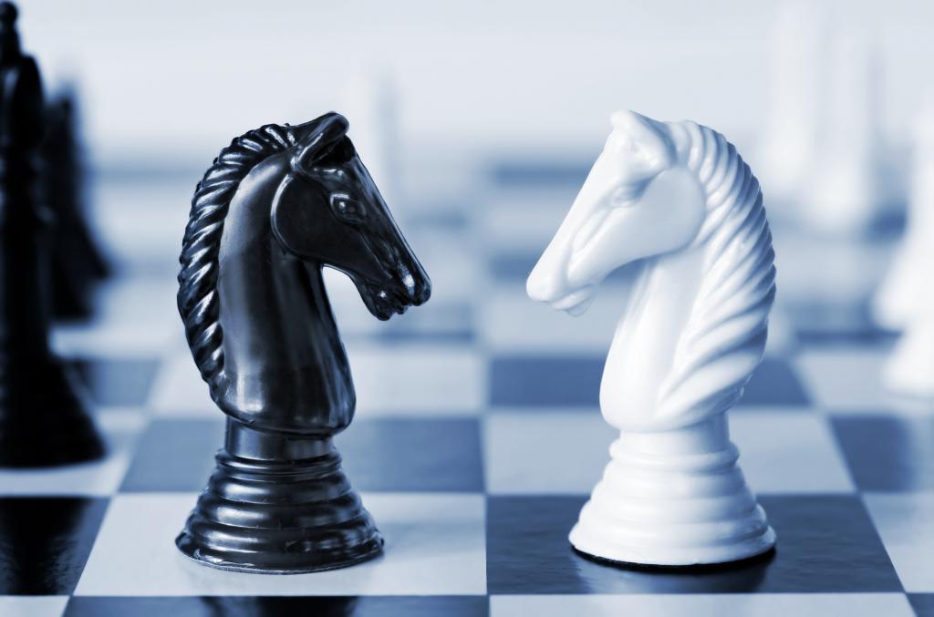 Black versus white chess knights on a board