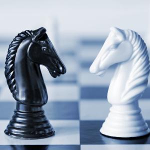 Black versus white chess knights on a board