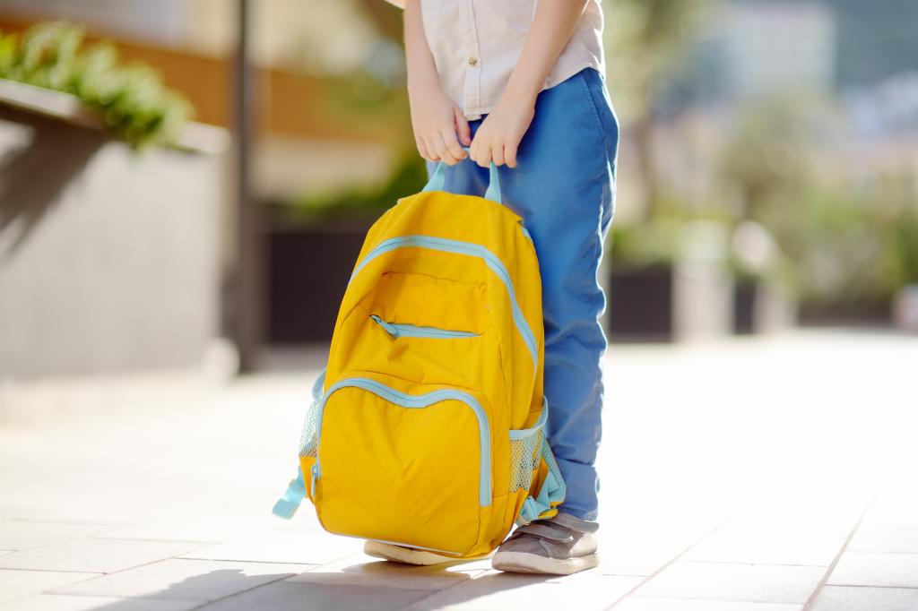 Child with a backpack on an empty street