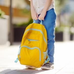 Child with a backpack on an empty street