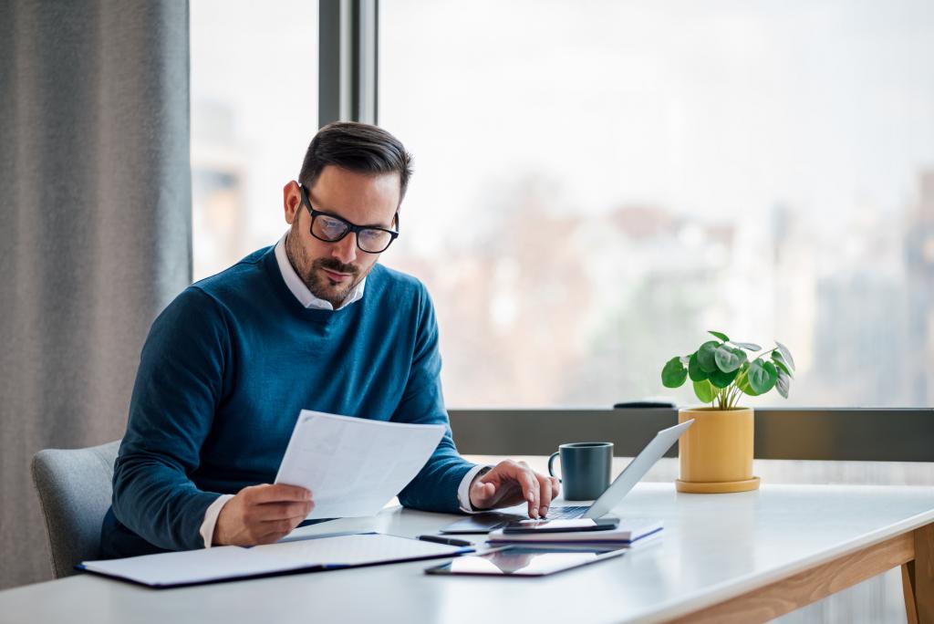 Adult male business owner checking the company budget in the files.