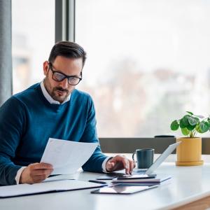 Adult male business owner checking the company budget in the files.