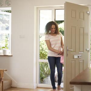 Woman Returning Home And Opening Front Door