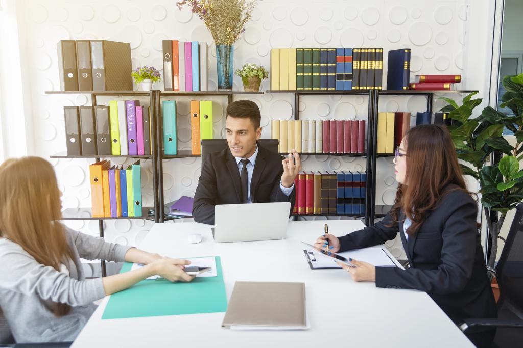 Concept showing solicitor-assisted mediation with a client, solicitor and mediator talking in an office room