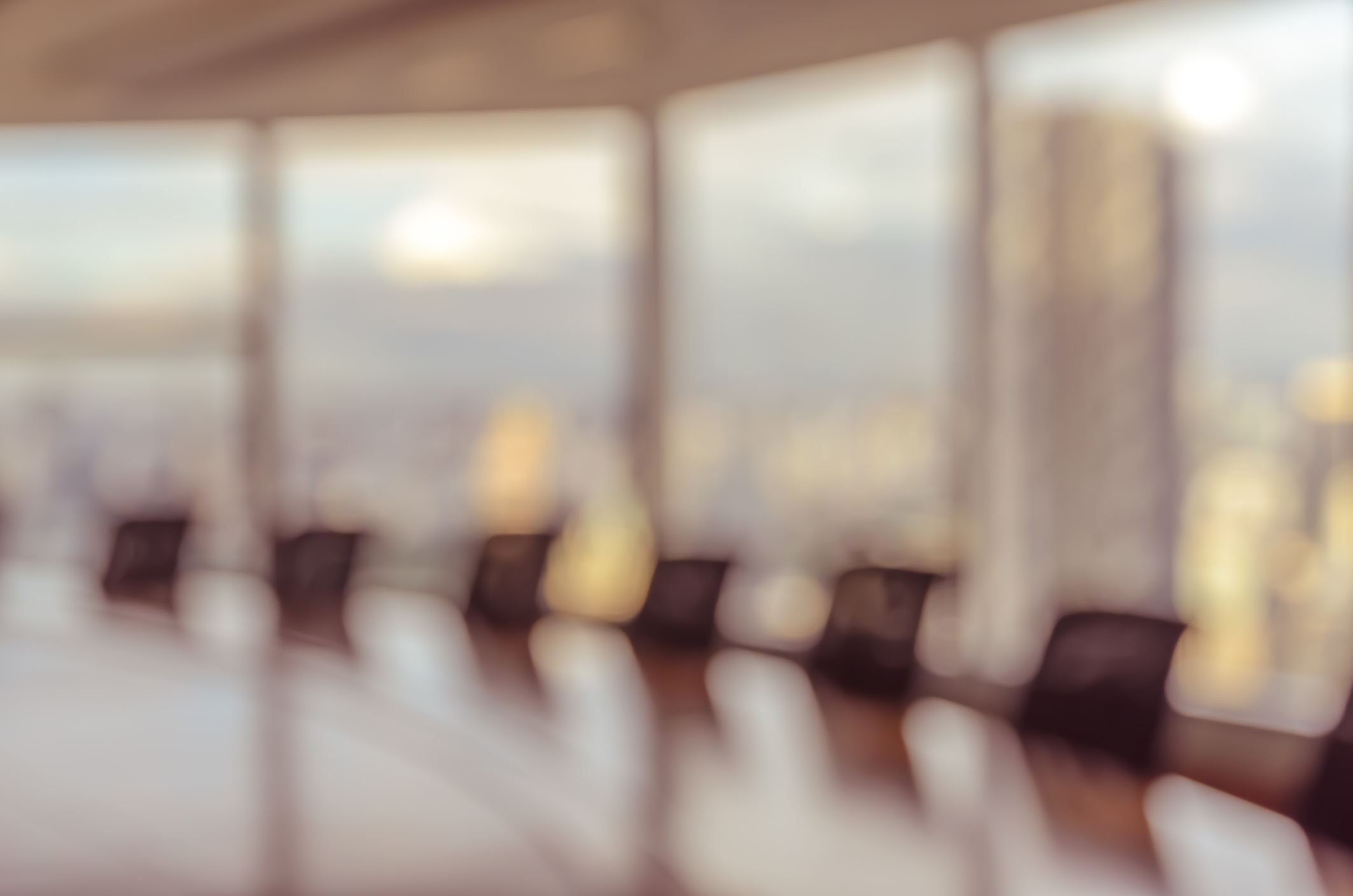 Blur image of empty boardroom with window cityscape background.