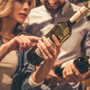 Couple at the supermarket checking a wine bottle label