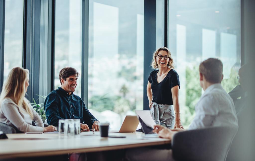 Office colleagues having casual discussion during meeting in conference room.
