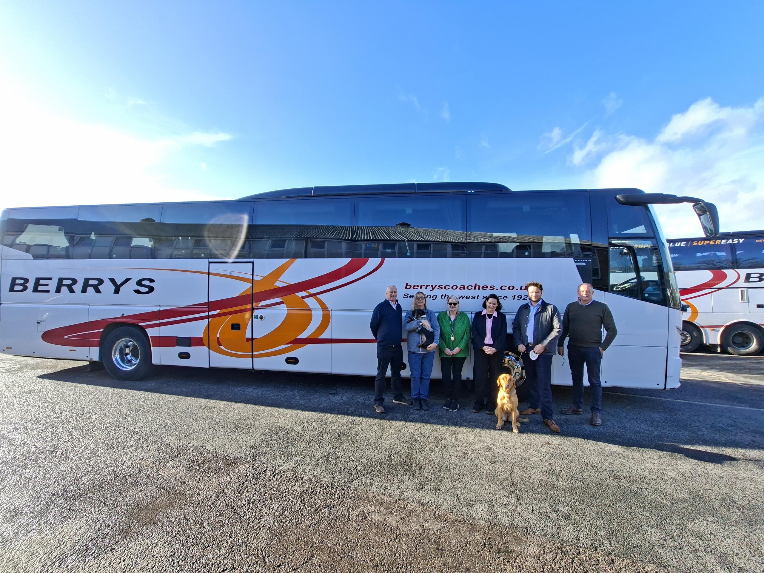 Photograph of Cat Carlton and Berrys Coaches owners stood in front of bus