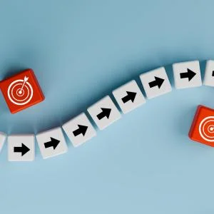 Concept of a roadmap showing directional tiles for movement and bullseyes for goals achieved