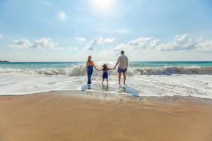 Family on beach holding hands, mother, father, child